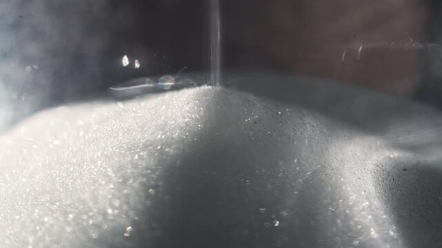White Sand Falling on Pile in Classic Hourglass Measuring Time Passage