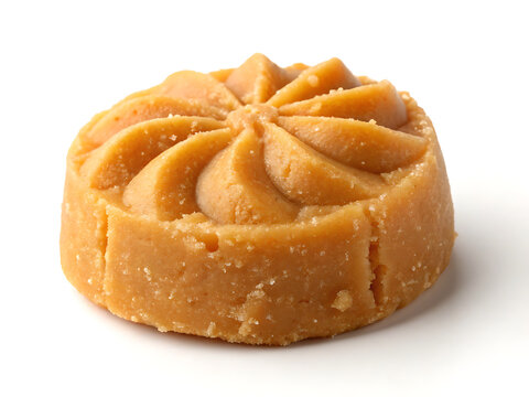 A single Mathura Peda, caramel-colored milk sweet, rustic handmade texture