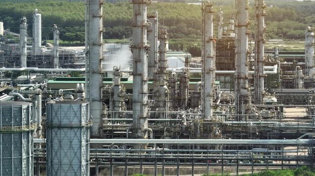 Drone perspective of a large-scale industrial facility with refining towers and energy systems, highlighting decarbonization challenges, energy transition, and heavy industry innovation. 4k.
