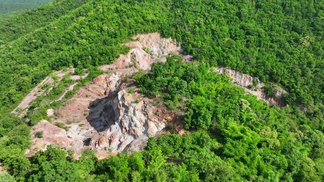 Aerial landscape showing mineral extraction areas among mountains, highlighting habitat fragmentation, geological damage, ESG risks, and the transition toward sustainable mining practices. 4k.
