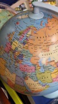 Map of Europe and Asia on a globe showing different countries and regions with labels in English, taken inside a store