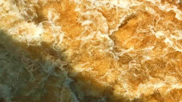 Aerial capture of intense muddy water movement during a flood event, highlighting extreme weather patterns, soil erosion, environmental imbalance, and the unpredictable force of natural disasters. 4k.
