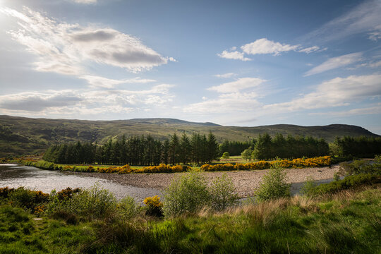 A bright, summer HDR landscape image of Strath More River in Strath More, just north of Altnaharra, Sutherland, Scotland.