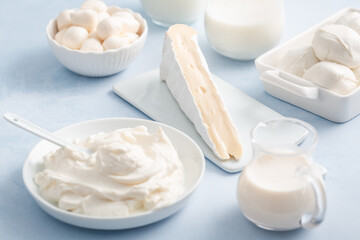 Fototapeta premium Delicious dairy products arranged on a light blue background for culinary inspiration