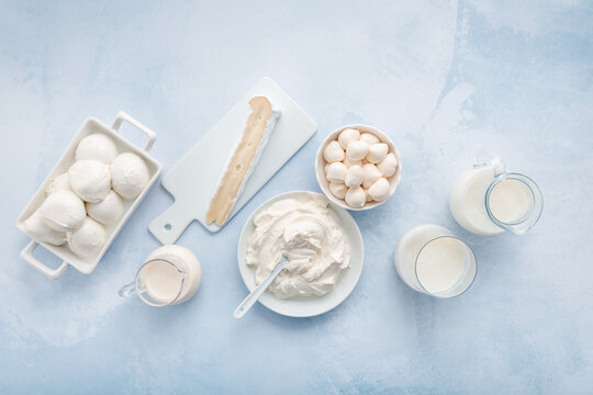 Delicious dairy products arranged on a light blue background for culinary inspiration