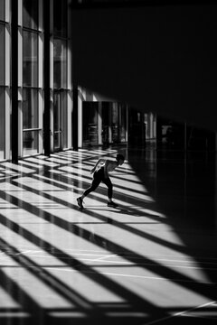 Person skateboarding in a sunlit hall. Urban skater riding in a modern architectural space.