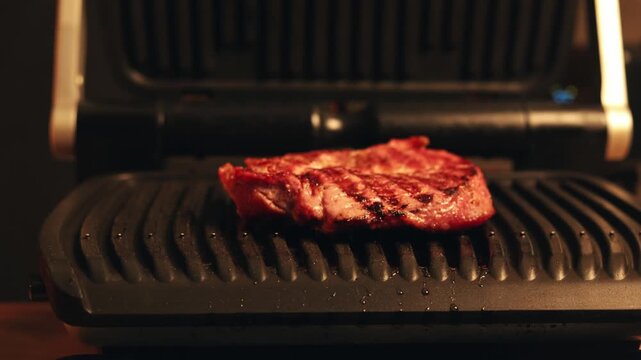 Juicy steak sizzling on a hot electric grill with sear marks