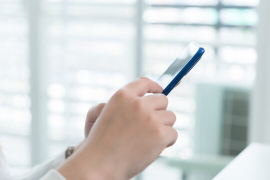 Young Businesswoman Working at Office Desk While Managing Documents and Mobile Communication.