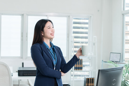 Young Businesswoman Working at Office Desk While Managing Documents and Mobile Communication.