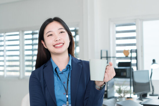 Young Businesswoman Working at Office Desk While Managing Documents and Mobile Communication.