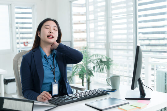 Young Businesswoman Working at Office Desk While Managing Documents and Mobile Communication.