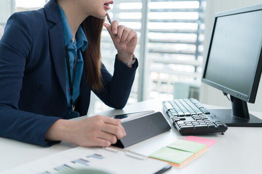 Young Businesswoman Working at Office Desk While Managing Documents and Mobile Communication.