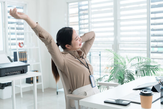 Young Businesswoman Working at Office Desk While Managing Documents and Mobile Communication.