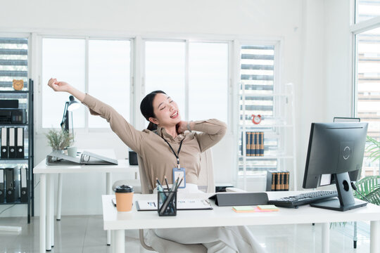 Young Businesswoman Working at Office Desk While Managing Documents and Mobile Communication.