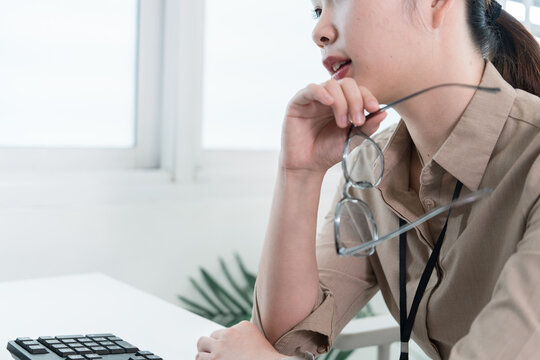 Young Businesswoman Working at Office Desk While Managing Documents and Mobile Communication.