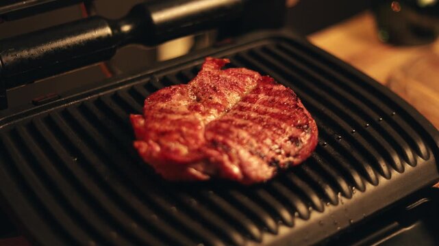 Juicy steak sizzling on a hot electric grill with sear marks