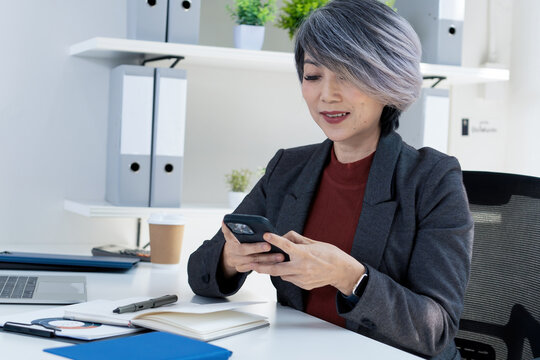 Businesswoman Texting on Smartphone at Office Desk