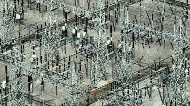 Aerial view of a large electrical substation illustrating smart grid development, renewable power connectivity, industrial engineering precision, and sustainable energy transition solutions. 4k.
