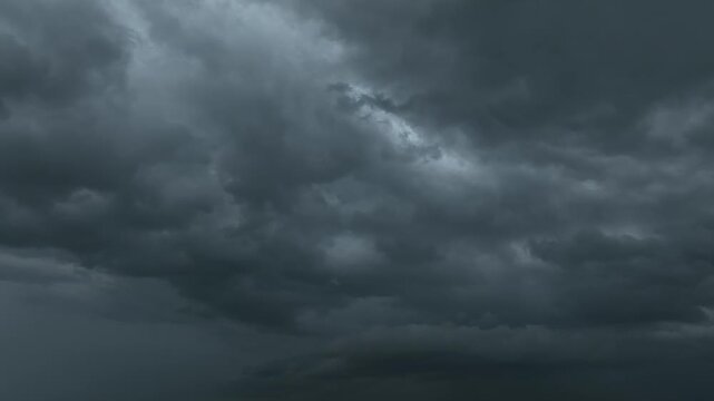 Aerial panoramic shot of a dark stormy sky with intense cloud formations, reflecting extreme weather events, climate change consequences, uncertainty management, dramatic cinematic sky potential. 4k.
