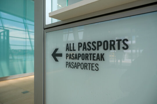 Mehrsprachiges Hinweisschild mit der Aufschrift &bdquo;Reisep&auml;sse&ldquo; in Englisch, Baskisch und Spanisch sowie Richtungspfeil im Kreuzfahrtterminal im Hafen von Getxo bei Bilbao in Nordspanien