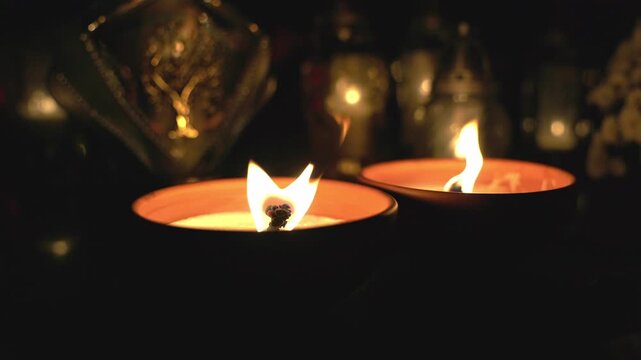 All Saints Day grave candles burning at night in cemetery.