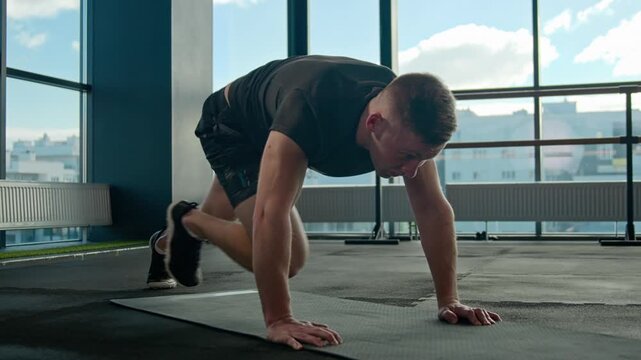 Healthy Caucasian athlete man male doing crossover mountain climber exercise on gym mat active sportsman cardio workout training abdominal muscles hips legs fitness exercising lifestyle body strength