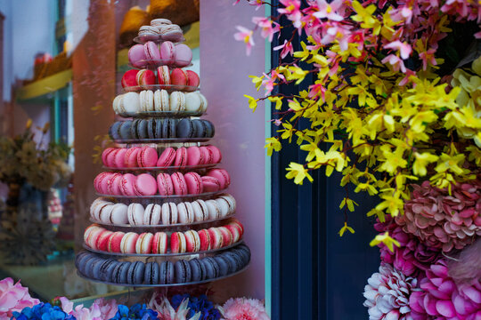 Macaron tower display outside colorful storefront window, Bruges