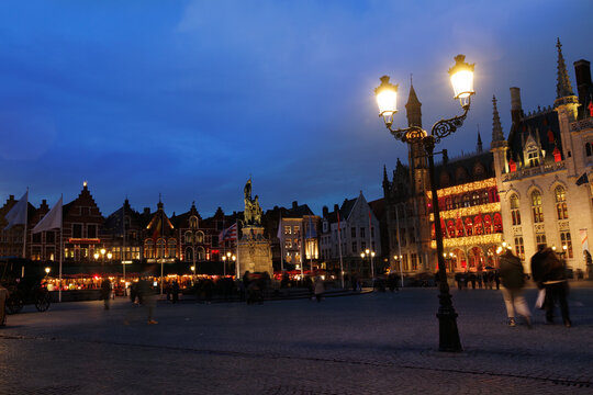 Nighttime city square with historic buildings and pedestrians