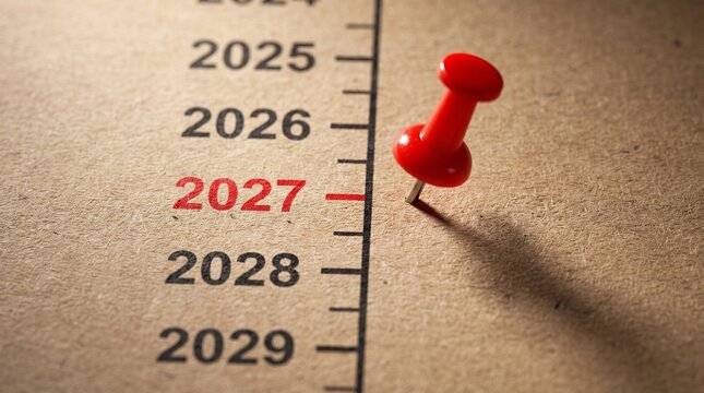 Red push pin marking year 2027 on vertical timeline calendar concept for strategic future planning with paper