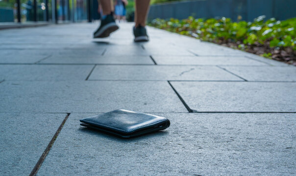 The lost wallet on the street, forgotten black leather object