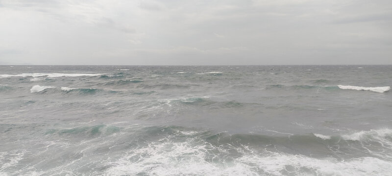 Mar picado con olas espumosas bajo cielo gris