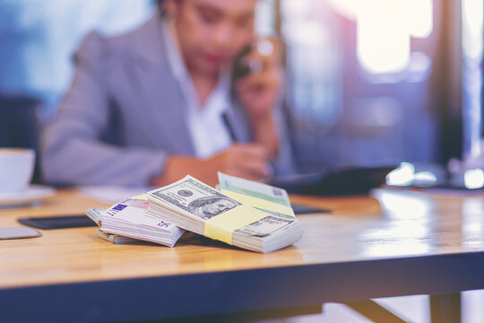 Cash money on the table with accountant woman working as blur background. Selected focus at money.