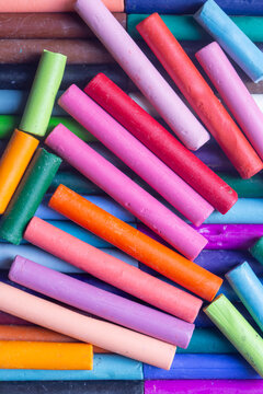 Pastels wax crayons, in various bright colours, background backdrop. Art and craft supplies concept