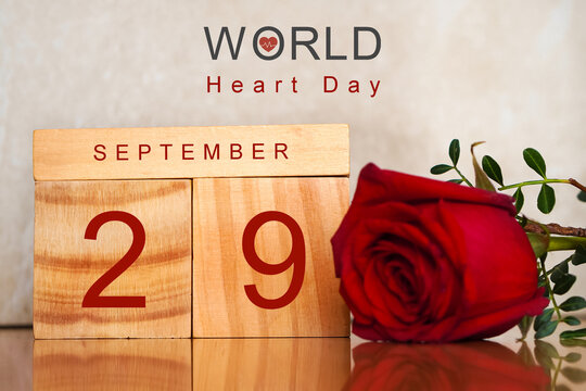 World Heart Day. September 29th. Wooden calendar next to a red rose
