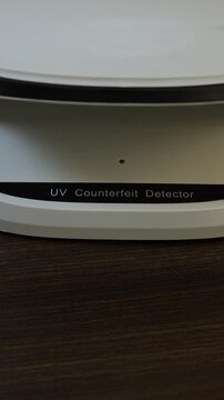 Examination of nepalese rupee (NPR) cash money with UV counterfeit detector. Concept of authenticity check, fight against counterfeiting of banknotes, anti fraud measures in Nepal. Close up view.