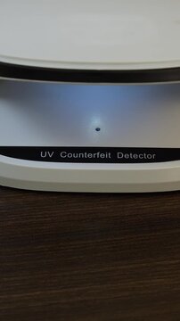 Examination of nepalese rupee (NPR) cash money with UV counterfeit detector. Concept of authenticity check, fight against counterfeiting of banknotes, anti fraud measures in Nepal. Close up view.