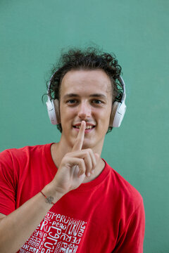 Young man making silence gesture with finger on lips