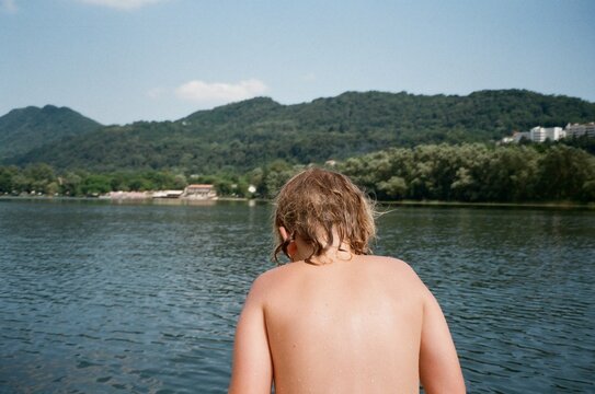 Child Overlooking Calm Mountain Lake