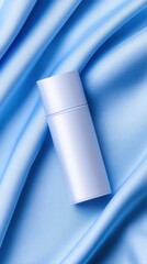 Naklejka premium A minimalistic lavender bottle placed elegantly on flowing satin fabric in a serene blue hue