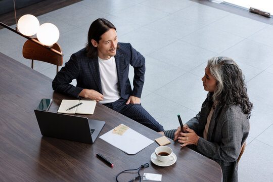 Business meeting, two professionals collaborate at a table.