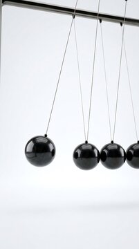 Newton cradle with polished obsidian spheres demonstrating physics