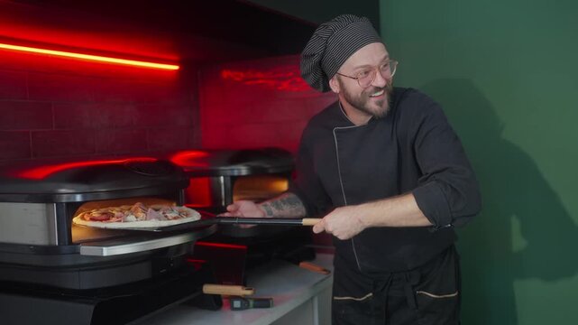 Male cheff putting four cheese pizza in oven using a shovel at kitchen. Young chef is going to bake delicious dish in furnace at cuisine restaurant. Process of making food at pizzeria