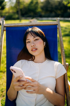 A woman using a mobile phone sitting outdoors