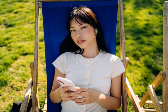 A woman using a mobile phone sitting outdoors