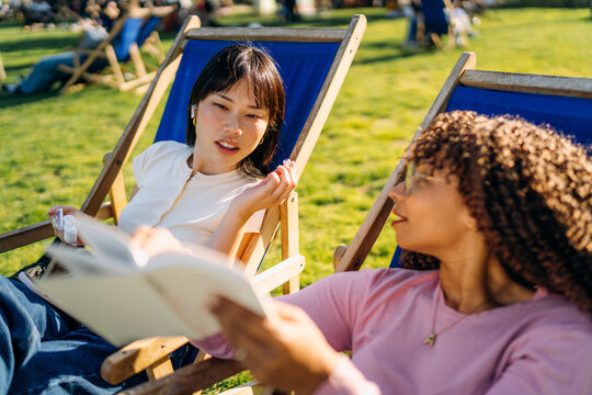 Two women relax sitting outdoors