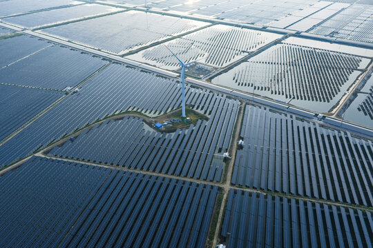  floating solar farm and wind turbines at sunset over water