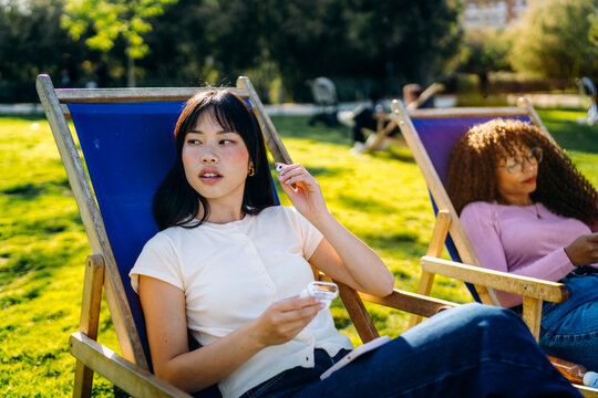 A woman wearing earpieces sitting outdoors