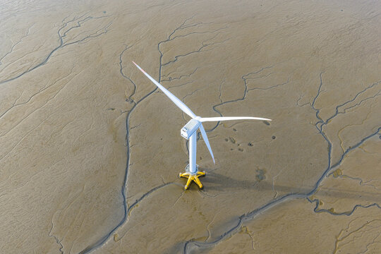 offshore wind turbine standing on tidal mudflat at low tide