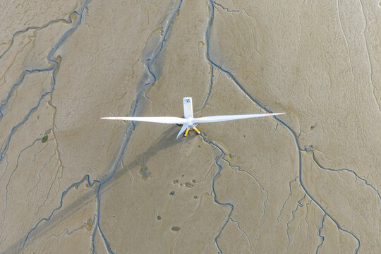 offshore wind turbine standing on tidal mudflat at low tide