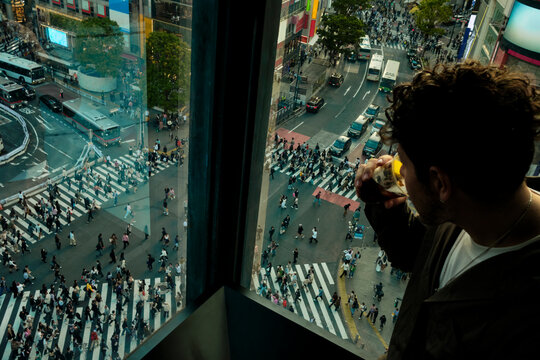 Man drinking While Overlooking Shibuya Crossing